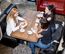 Drei Frauen sitzen zusammen am Tisch, trinken Kaffee und essen Kuchen, Draufsicht